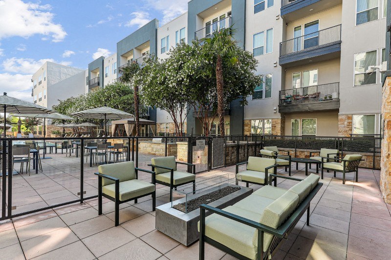 an outdoor patio with tables and chairs and buildings