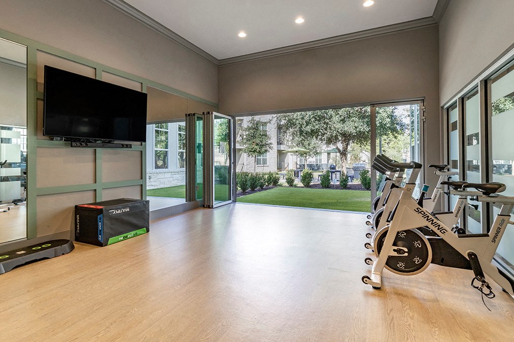 a home gym with a spin bike and a tv on the wall