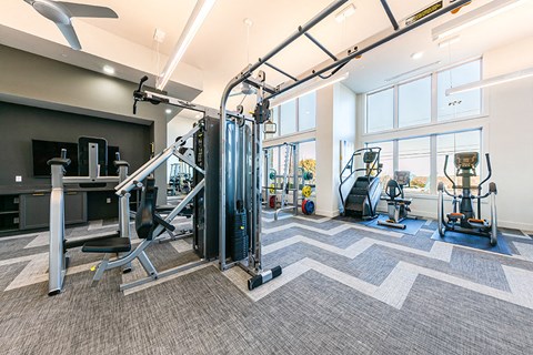 a gym with cardio machines and weights at the flats at west end apartments