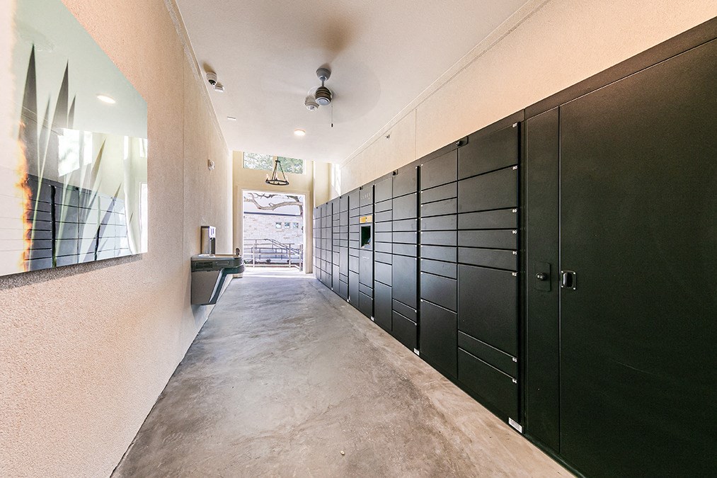 a long hallway with black doors and a mirror on the wall
