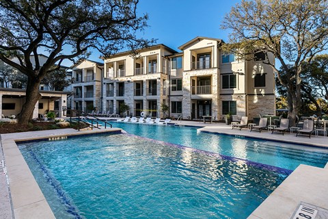 a swimming pool with an apartment building in the background