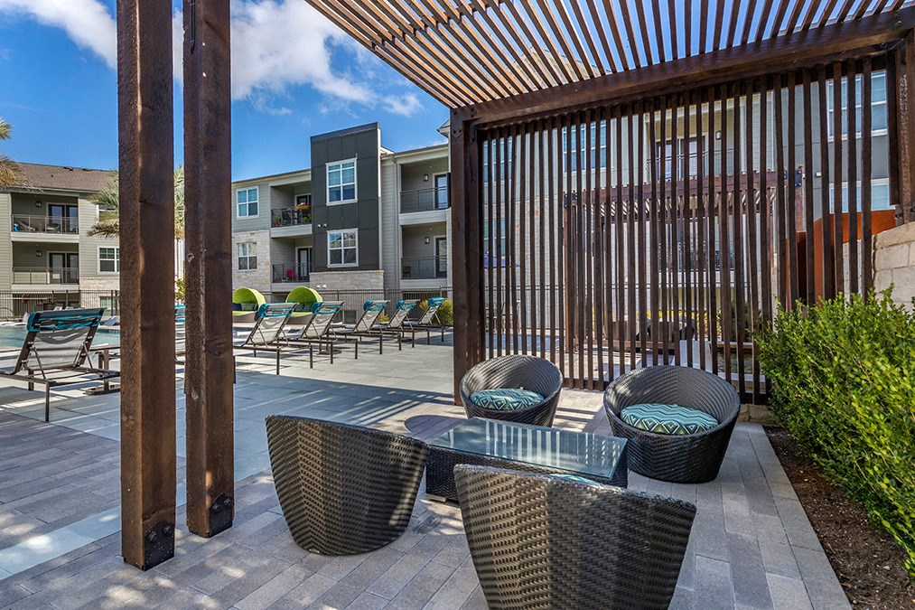 a patio with tables and chairs and a pergola