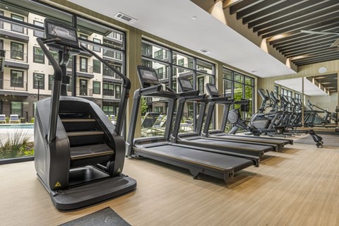 A gym with treadmills and elliptical machines.