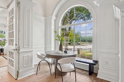 a dining room with a large window and a table and chairs