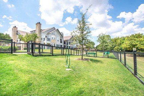 A large house with a fenced yard and a green lawn.