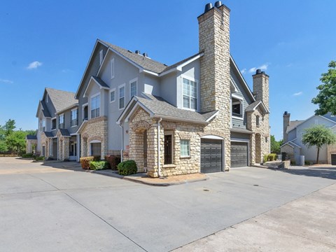 A large house with a stone chimney and a garage.