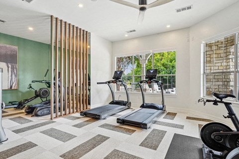 a home gym with exercise machines and a window
