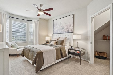 a bedroom with a ceiling fan and a bed