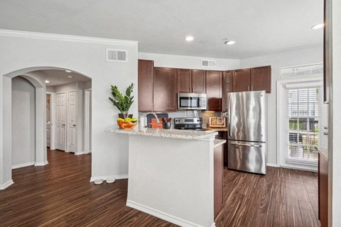 a kitchen with a island and a stainless steel refrigerator