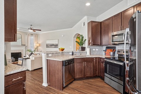 a large kitchen with wooden cabinets and stainless steel appliances
