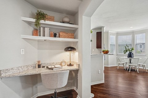 a home office with a desk and a kitchen with a table and chairs