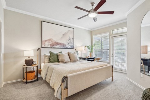 a bedroom with a large bed and a ceiling fan