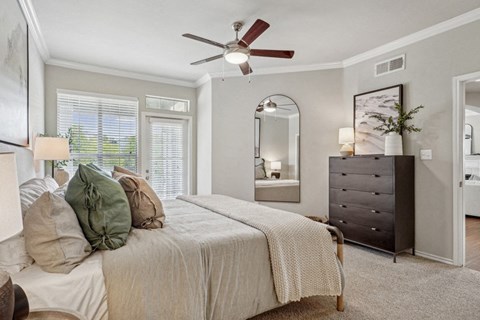 a bedroom with a large bed and a ceiling fan