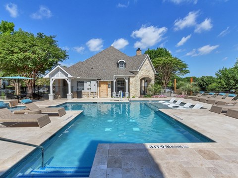 A large house with a pool in front.