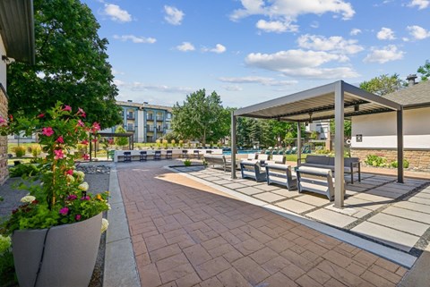 A sunny day at the park with benches and a pavilion.