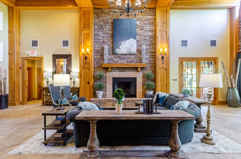 a large living room with a stone fireplace and a wooden table