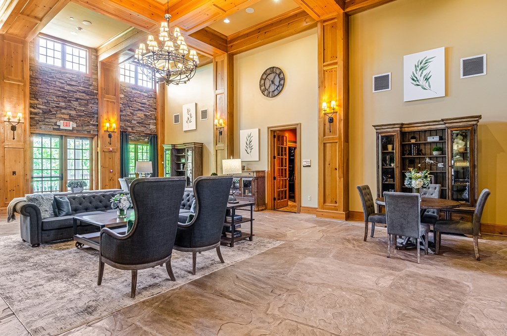 a living room with a table and chairs and a clock on the wall