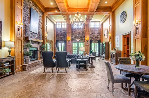 a large lobby with chairs and tables and a fireplace