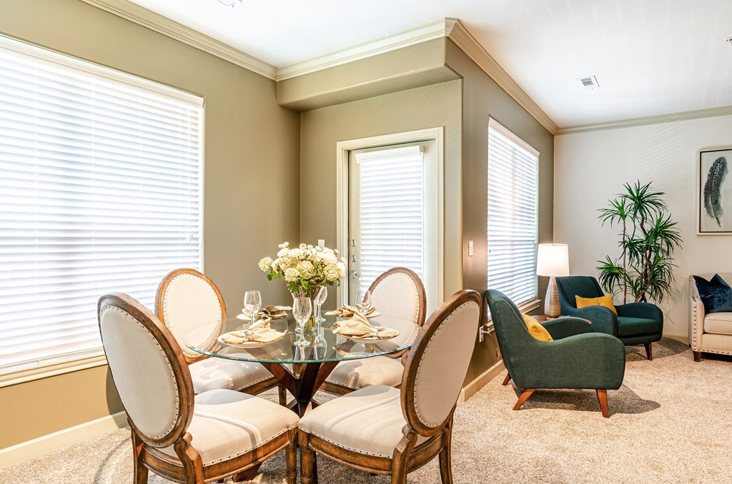a dining room with a glass table and chairs