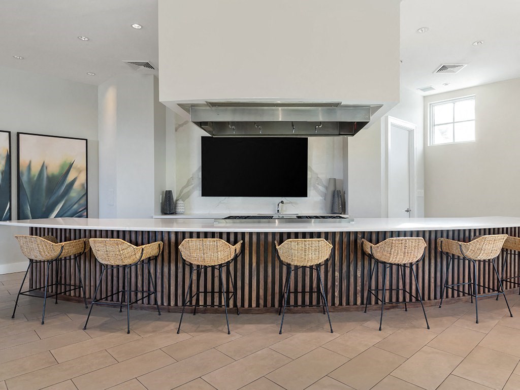 a kitchen with a long counter and a tv above it