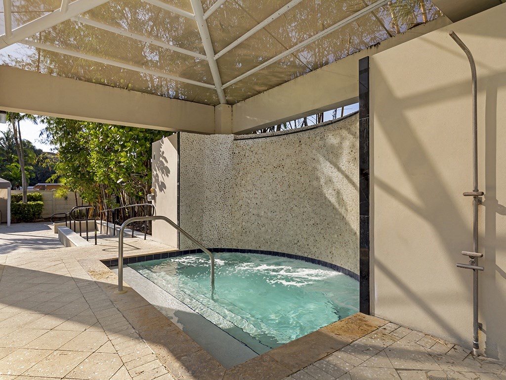 a hot tub with a stone wall and a glass ceiling