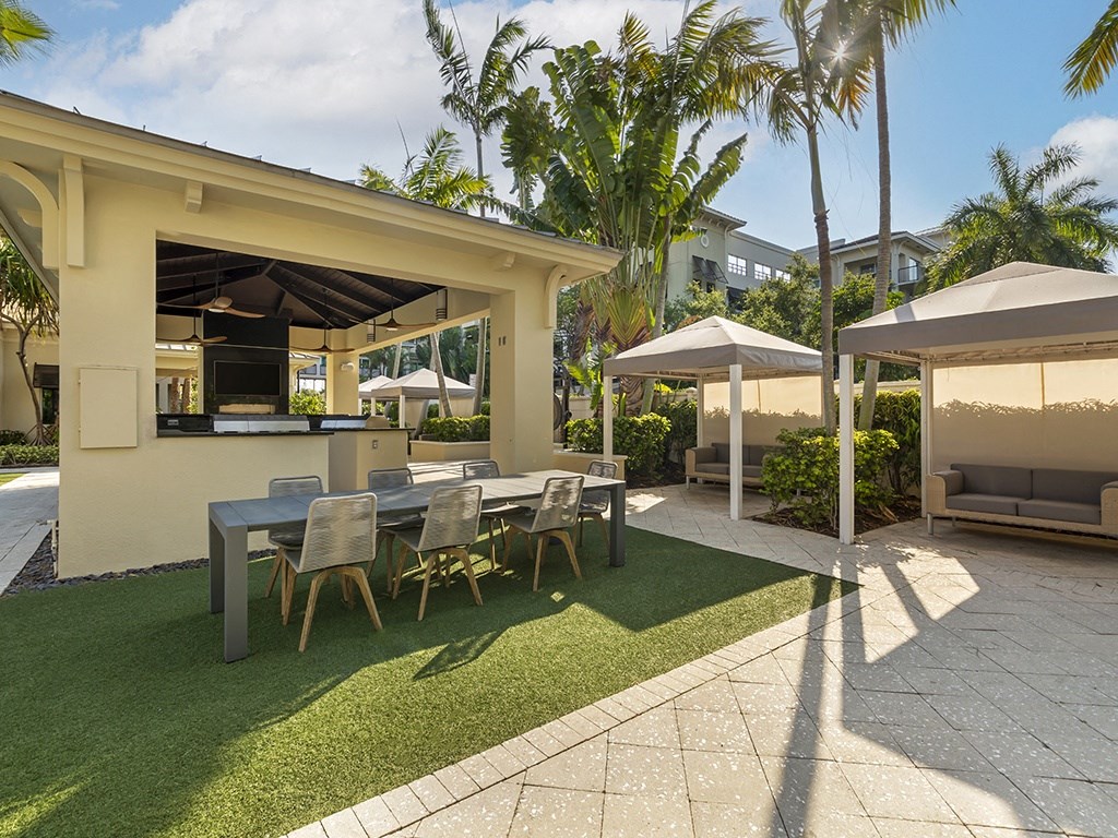a patio with a table and chairs and umbrellas