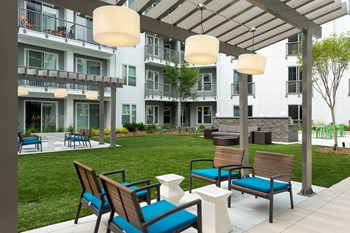 outdoor courtyard with green space and lounge chairs - Photo Gallery 13
