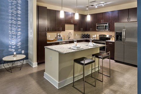 model home kitchen with stainless steel appliances and island