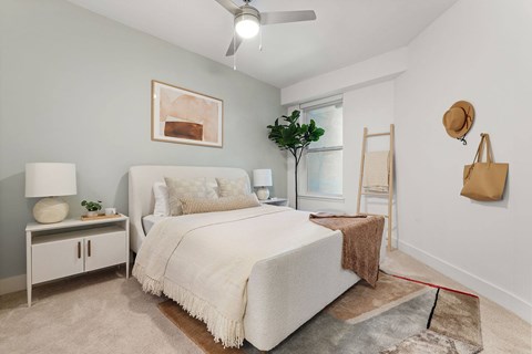 A bedroom with a white bed and a brown rug.