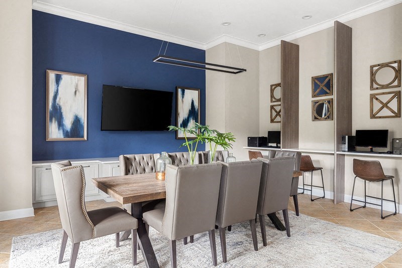a dining area with a table and chairs and a tv on the wall