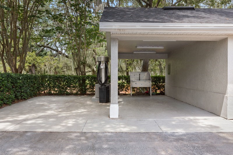 a carport with a bench and a water dispenser