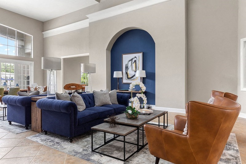 a living room with a blue couch and a brown leather chair