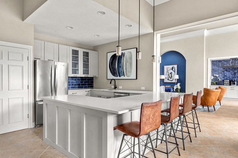 a kitchen with white cabinets and a large island with a white countertop