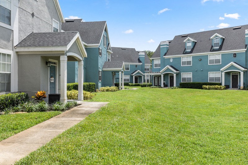 a grassy yard in front of a row of houses