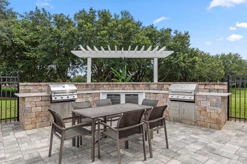 a patio with an outdoor kitchen and a pergola