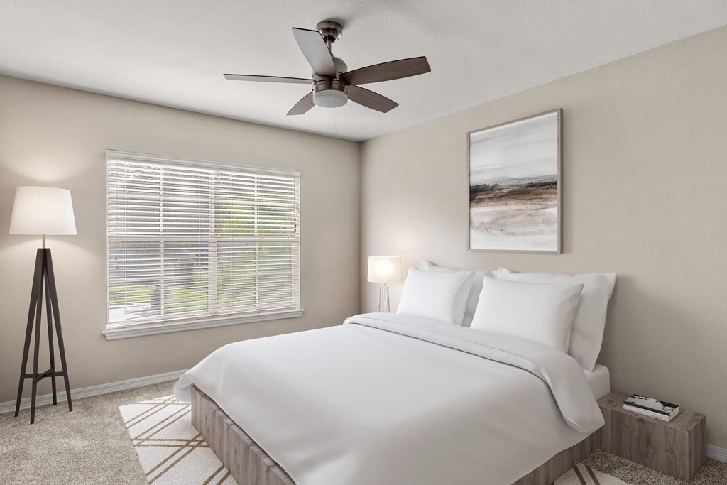 a bedroom with a large bed and a ceiling fan