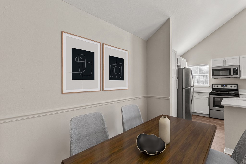 a dining room with a table and chairs and a kitchen with a refrigerator