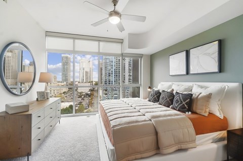 A bedroom with a large bed and a view of the city.