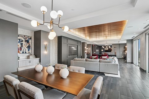A modern dining room with a wooden table and grey chairs.