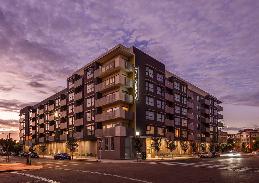a large apartment building on a city street at dusk