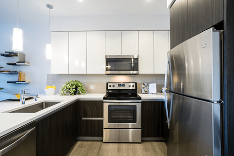 A modern kitchen with a stainless steel refrigerator and oven.