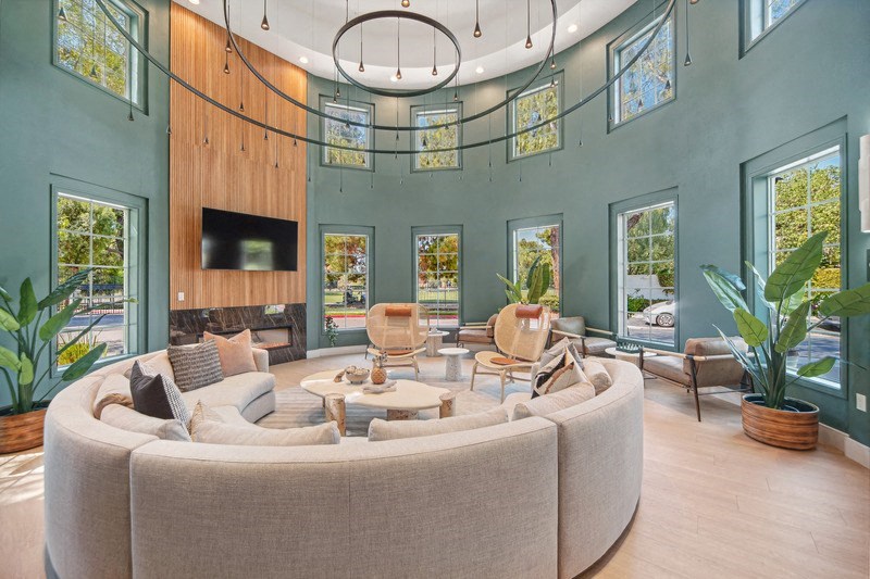 a living room with a large round couch and a tv