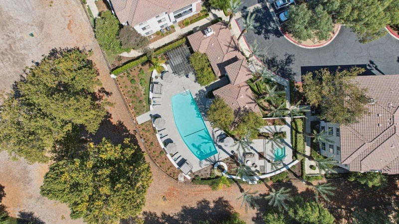 an aerial view of a pool in the backyard of a house