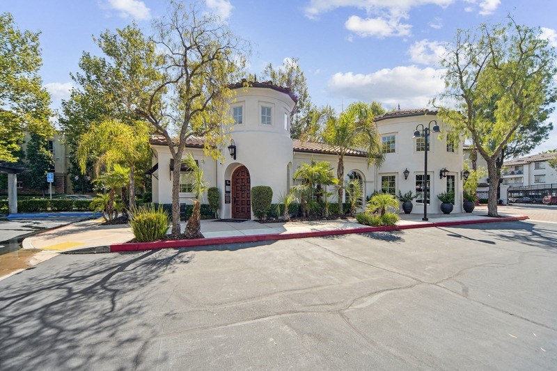 a building with a driveway and trees in front of it