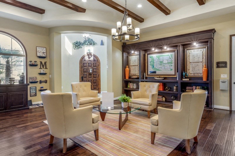 a living room with white chairs and a table