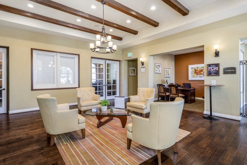 a living room with white chairs and a coffee table