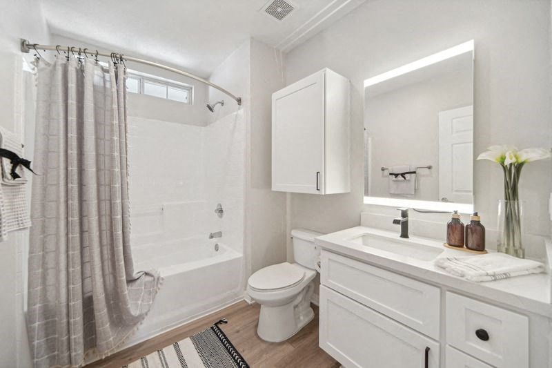 a white bathroom with a shower toilet and sink