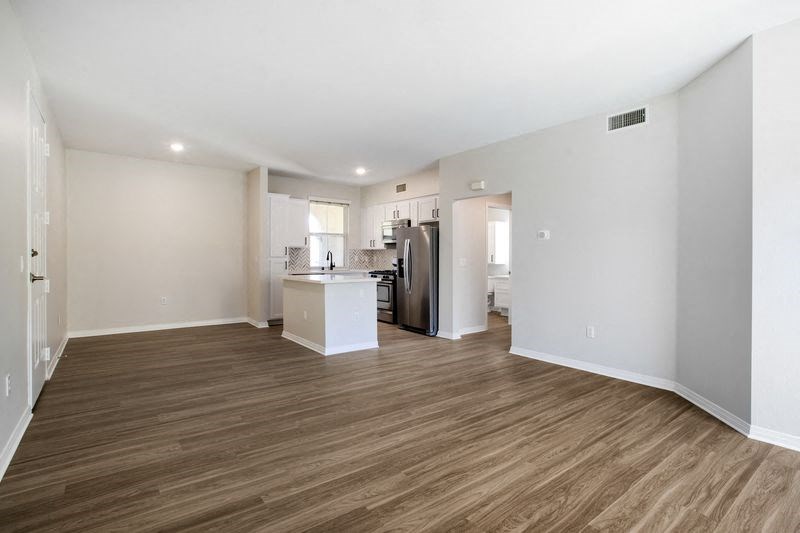 a living room and kitchen with a wood floor