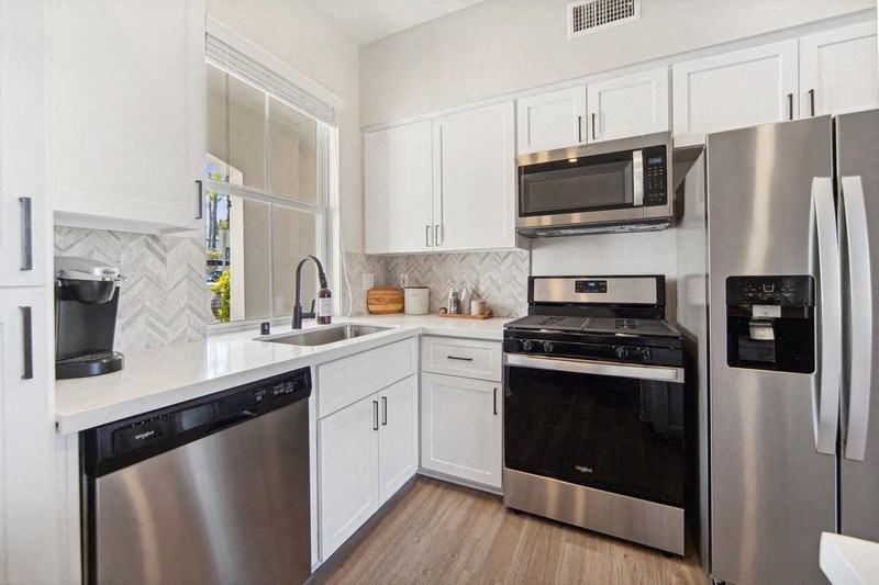 a kitchen with stainless steel appliances and white cabinets