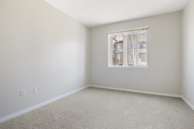 an empty room with white walls and a window
